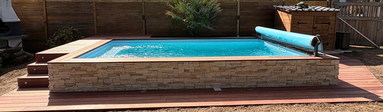 Piscine clé en main LC Création avec parement pierre, margelles bois et terrasse intégrée